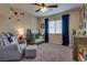 Cozy bedroom with a neutral color scheme, ceiling fan, and comfortable seating at 7919 Mineral Peak St, Las Vegas, NV 89166