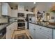 Modern kitchen with white cabinets, granite countertops, stainless steel appliances, and island at 7919 Mineral Peak St, Las Vegas, NV 89166