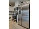 Stainless steel refrigerator in the kitchen complements white cabinets and tiled flooring at 7919 Mineral Peak St, Las Vegas, NV 89166