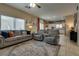 Spacious living room with plenty of seating and natural light and seamlessly flowing into the kitchen at 7919 Mineral Peak St, Las Vegas, NV 89166