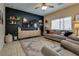 Cozy living room featuring dark accent wall, comfortable seating, and ample natural light at 7919 Mineral Peak St, Las Vegas, NV 89166