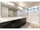 Modern bathroom featuring double sinks, a walk-in shower, and a large mirror at 8179 Shale Canyon St, Las Vegas, NV 89139