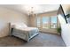 Bedroom with a queen-size bed, three windows, and a mounted TV at 8179 Shale Canyon St, Las Vegas, NV 89139