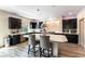 Modern kitchen with dark cabinets, stainless steel appliances, an island, and light wood flooring at 8179 Shale Canyon St, Las Vegas, NV 89139