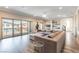 Bright living room featuring hardwood floors, a large sectional couch, and sliding glass doors at 8179 Shale Canyon St, Las Vegas, NV 89139