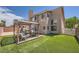 Well-maintained backyard with patio area, a covered outdoor dining set, and artificial grass at 8324 Brittany Harbor Dr, Las Vegas, NV 89128
