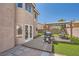 Charming backyard featuring a patio area, a covered outdoor dining set, and artificial grass at 8324 Brittany Harbor Dr, Las Vegas, NV 89128
