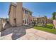 Charming backyard with a stone patio, covered outdoor dining, and pristine artificial grass at 8324 Brittany Harbor Dr, Las Vegas, NV 89128