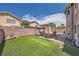 Spacious backyard with a covered outdoor dining set and pristine artificial grass at 8324 Brittany Harbor Dr, Las Vegas, NV 89128