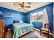 Bright bedroom with blue walls, whimsical cloud painting, and a cozy quilt on the bed at 8324 Brittany Harbor Dr, Las Vegas, NV 89128