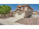 Side view of home featuring large driveway with brick accent, two-car garage, desert landscaping, and small fenced yard at 8324 Brittany Harbor Dr, Las Vegas, NV 89128