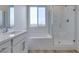 Bathroom featuring a tiled shower with glass door, soaking tub, and neutral-toned vanity at 844 Aurelie Ridge St, Henderson, NV 89011