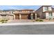 Charming two-story home featuring a three car garage, stone accents, manicured landscaping, and a brick driveway at 844 Aurelie Ridge St, Henderson, NV 89011