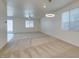 Bright living room featuring neutral walls, large windows, modern lighting, and plush carpeting at 844 Aurelie Ridge St, Henderson, NV 89011