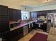 Modern kitchen featuring dark cabinetry, granite countertops, and stainless steel appliances at 853 Rusty Anchor Way, Henderson, NV 89002