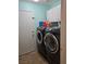 Laundry room featuring front loading washer and dryer, white cabinets and tile flooring at 853 Rusty Anchor Way, Henderson, NV 89002