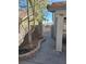 View of the side yard featuring a walkway and small trees planted along a brick border, leading to a gate at 853 Rusty Anchor Way, Henderson, NV 89002