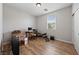 Simple bedroom with hardwood floors and a window, furnished with desk and weights at 9121 Ripple Ridge Ave # 101, Las Vegas, NV 89149