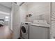 Laundry room with both washer and dryer units, wood-style floors, and overhead storage at 9121 Ripple Ridge Ave # 101, Las Vegas, NV 89149
