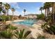 Community pool with chairs and palm trees in a tropical setting at 9121 Ripple Ridge Ave # 101, Las Vegas, NV 89149