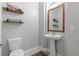 Bathroom features a pedestal sink, decorative shelves, and a toilet at 9144 Irish Elk Ave, Las Vegas, NV 89149