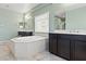 Bathroom with dual sinks, large bathtub, and neutral tile flooring at 9144 Irish Elk Ave, Las Vegas, NV 89149