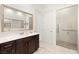 Well-lit bathroom showcasing a glass-door shower, sink and ample storage at 9889 Gemstone Sunset Ave, Las Vegas, NV 89148