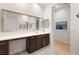 Bright bathroom boasts a large mirror, vanity with storage, and stylish contemporary finishes at 9889 Gemstone Sunset Ave, Las Vegas, NV 89148