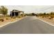 Community entrance with modern architecture, desert landscaping, and paved road leading into the community at 9889 Gemstone Sunset Ave, Las Vegas, NV 89148