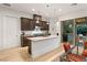 Kitchen with granite countertops, wood cabinets, stainless steel appliances, and backyard patio access at 9889 Gemstone Sunset Ave, Las Vegas, NV 89148