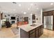 Open-concept kitchen with granite counters, stainless steel appliances, and hardwood floors overlooking the living area at 9889 Gemstone Sunset Ave, Las Vegas, NV 89148