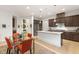 Open kitchen featuring wooden cabinets, stainless steel appliances, granite countertops, and a central island with bar seating at 9889 Gemstone Sunset Ave, Las Vegas, NV 89148