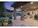 Covered patio with pavers, outdoor seating, and lush landscaping creates a relaxing outdoor living space at 9889 Gemstone Sunset Ave, Las Vegas, NV 89148