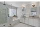 Bright bathroom featuring double sinks, granite countertop, tiled shower and a large tub at 10004 W Cherokee Ave, Las Vegas, NV 89147