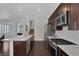 Open concept kitchen with stainless steel appliances, granite countertops, and dark wood cabinetry at 10004 W Cherokee Ave, Las Vegas, NV 89147