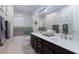 Modern bathroom features a large vanity with dual sinks, sleek fixtures, and a shower at 10356 Addie De Mar Ln, Las Vegas, NV 89135