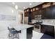 Bright kitchen with stainless steel appliances, dark cabinetry, and a marble island with seating at 10356 Addie De Mar Ln, Las Vegas, NV 89135