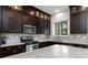 Updated kitchen featuring dark wood cabinets, stainless steel appliances, and light granite countertops at 10356 Addie De Mar Ln, Las Vegas, NV 89135