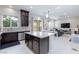 Open-concept kitchen featuring dark cabinets, a large island, stainless appliances, and bright, natural light at 10356 Addie De Mar Ln, Las Vegas, NV 89135