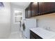 Functional laundry room with modern appliances, white cabinetry, and a utility sink at 10356 Addie De Mar Ln, Las Vegas, NV 89135