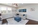 Cozy living room with stylish sectional sofa, ottoman, dark hardwood floors, and recessed lighting at 10356 Addie De Mar Ln, Las Vegas, NV 89135