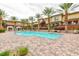 Beautiful community pool area surrounded by palm trees, lounge chairs, and cabanas at 10356 Addie De Mar Ln, Las Vegas, NV 89135
