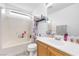 This bathroom features a white shower-tub combo, toilet, and wood vanity at 10365 Cherokee Corner Ave, Las Vegas, NV 89129