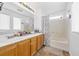 This bathroom features dual sinks, wood cabinets, and a shower-tub combo at 10365 Cherokee Corner Ave, Las Vegas, NV 89129