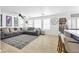 Bright and open living room featuring a comfortable sectional couch and a view into the kitchen at 10365 Cherokee Corner Ave, Las Vegas, NV 89129