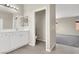 Well-lit bathroom with double vanity, large mirror, and an adjacent toilet room at 10529 Mount Blackburn Ave, Las Vegas, NV 89166