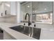 Close-up of kitchen sink featuring modern faucet, white countertops, and a view to the backyard at 108 Appian Way, Henderson, NV 89002