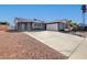 Exterior of the home featuring a spacious driveway, desert landscaping, and mature palm trees at , Las Vegas, NV 89145