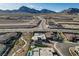 Expansive aerial view of a desert property with a modern home, landscaping, pool and mountain views at 12199 Canyon Sunset St, Las Vegas, NV 89138