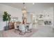 Elegant dining area with a modern chandelier, a round table set for six, and an open view to the kitchen at 12199 Canyon Sunset St, Las Vegas, NV 89138